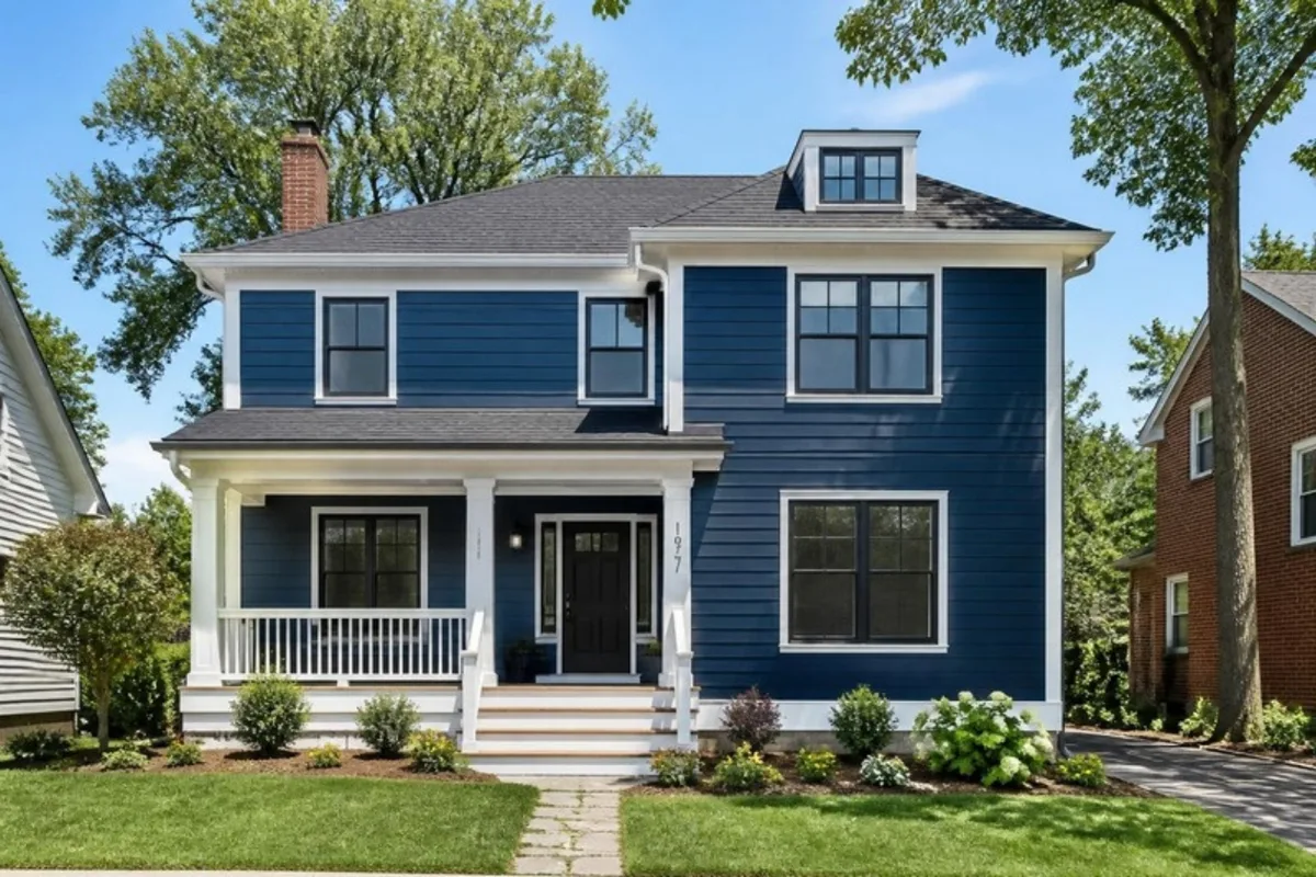 Home exterior with new navy siding, white trim and landscaping
